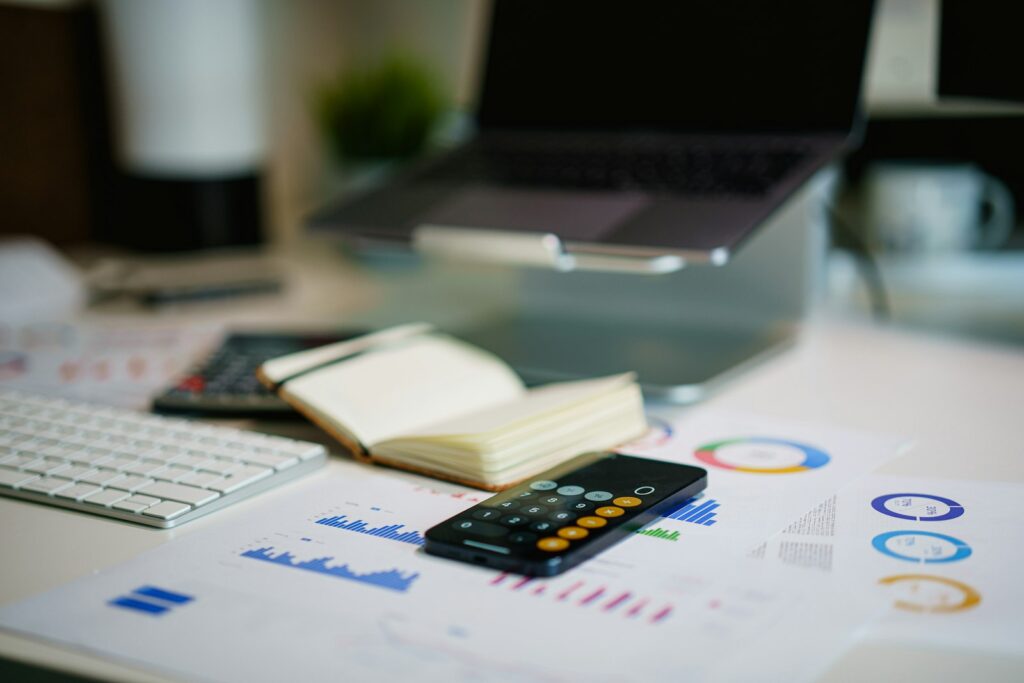 An office desk with a smartphone and printed financial charts