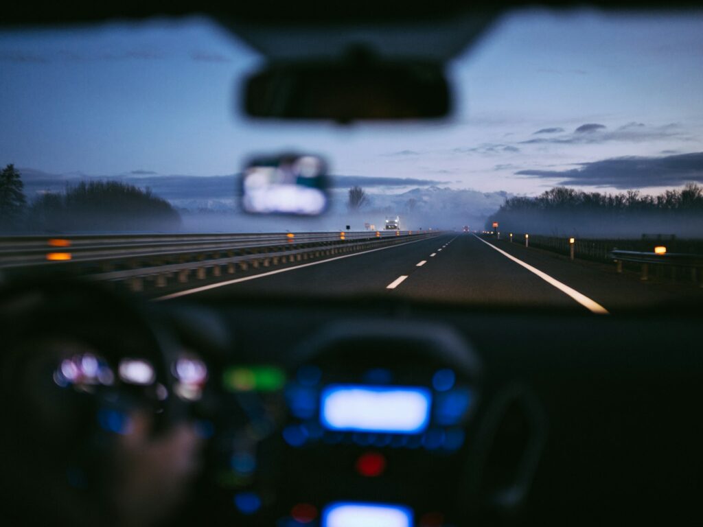 A view from inside a car driving on a misty highway