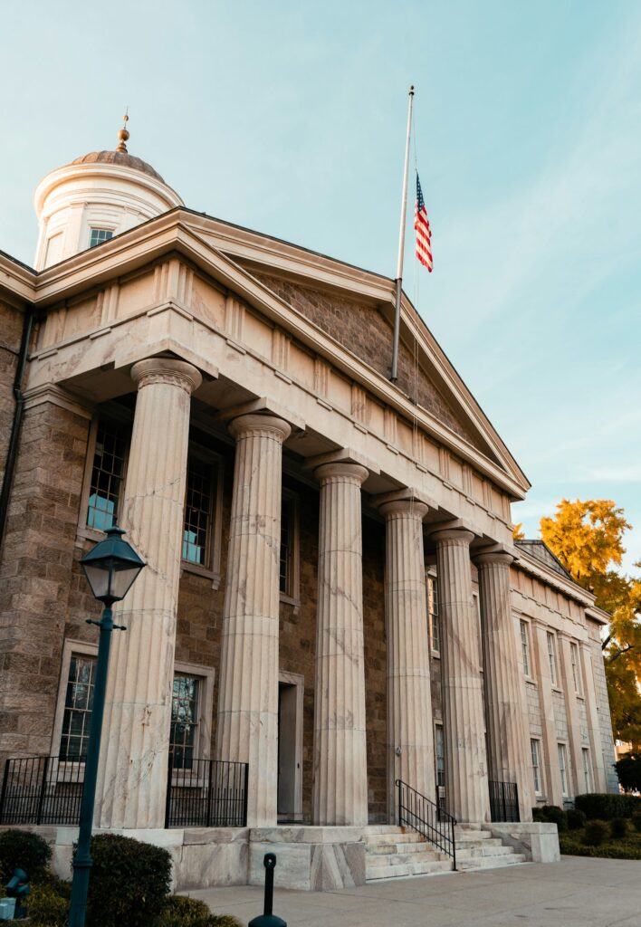 A government building with stone columns and a flag on top