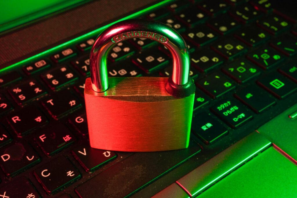 A red padlock resting on a black computer keyboard, representing cybersecurity