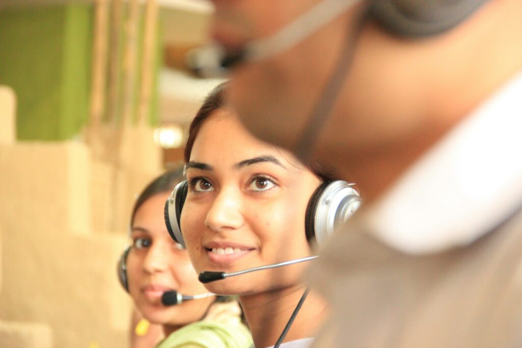 Two women wearing headsets in a bright customer service office