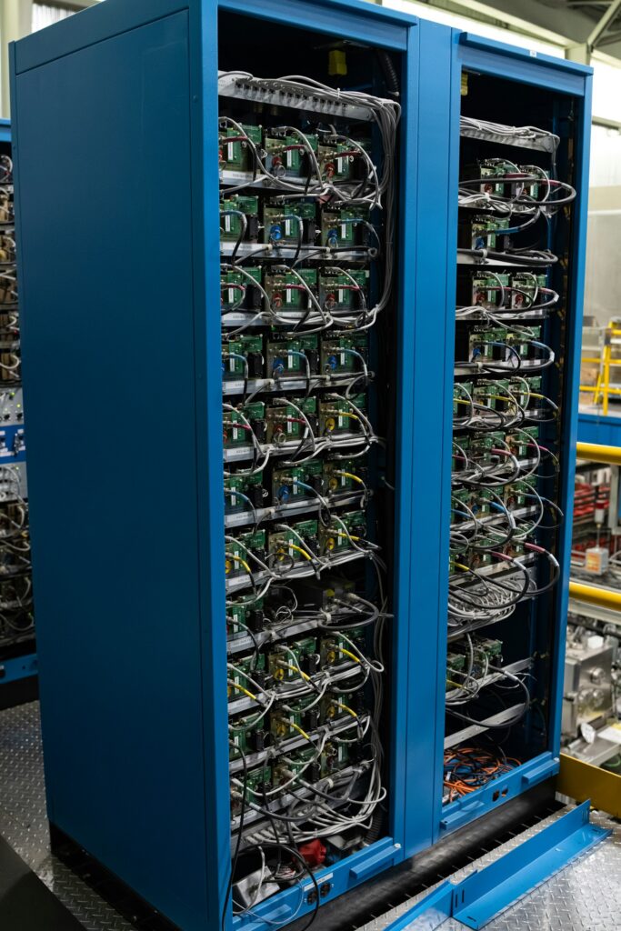 Two blue cabinets filled with complex electronics in a computing hall